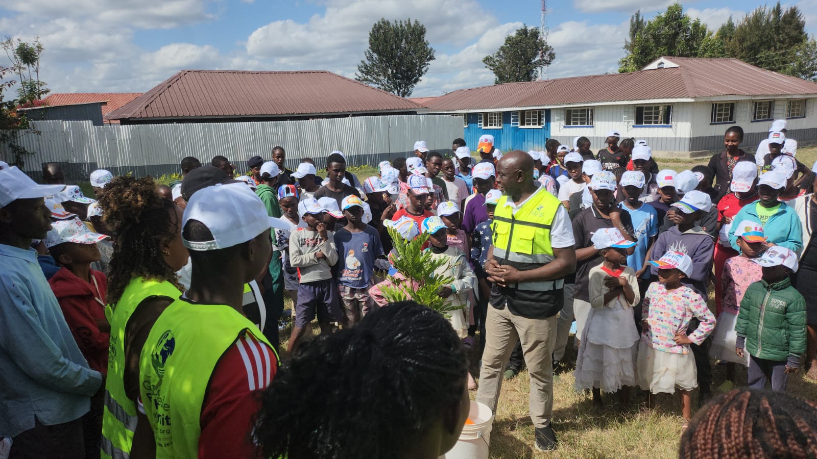 GRH Team with children lucks after poring water on the trees.
