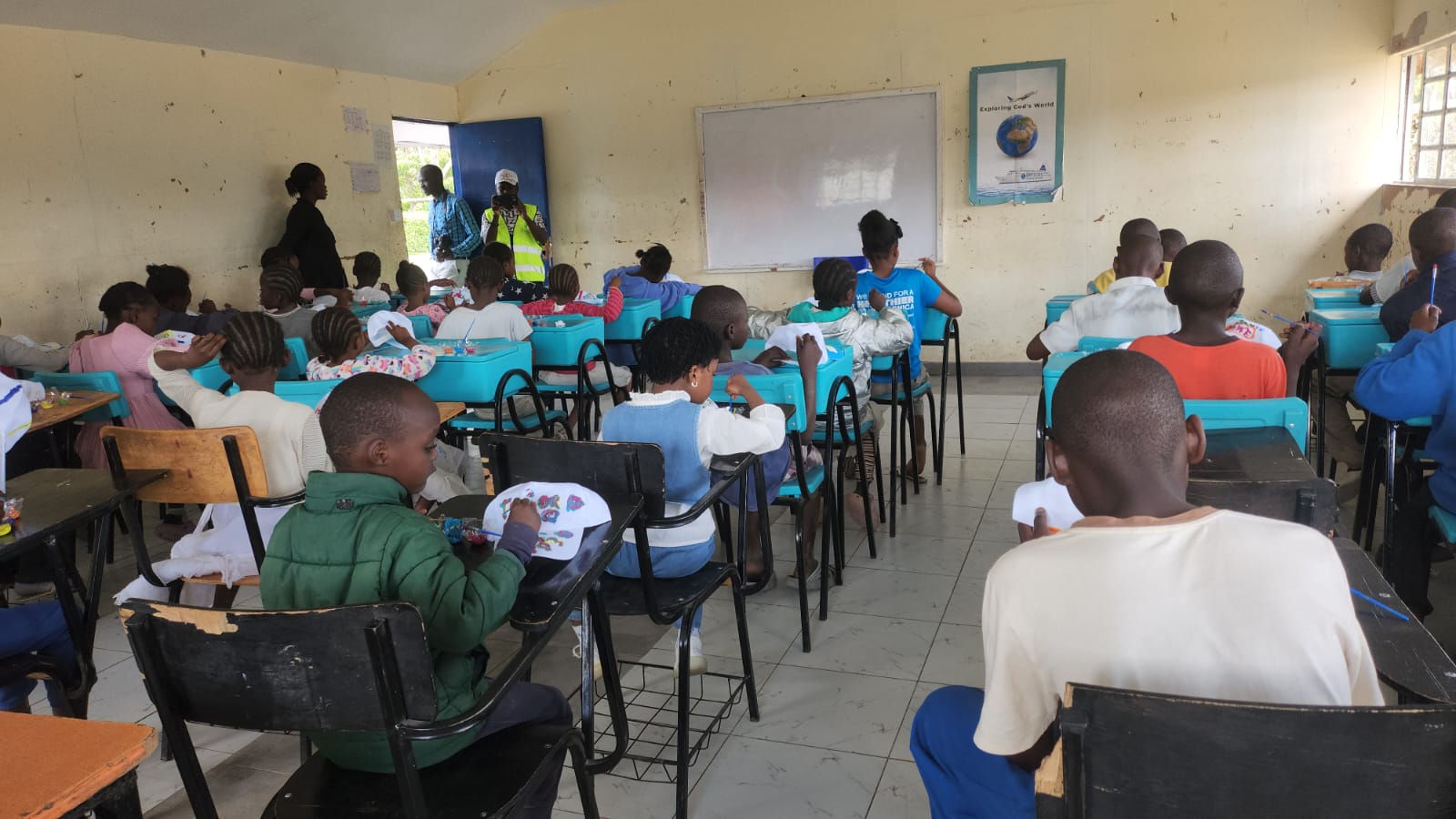 Children in class making some paintings on white hats